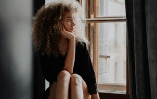 Woman Sitting on Bathroom Windowsill