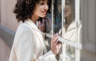 Woman Looking Through Window in White Blazer