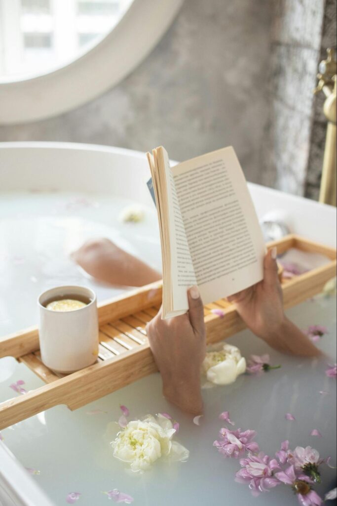 Person in Bathtub with Flowers, Book, Coffee and Window