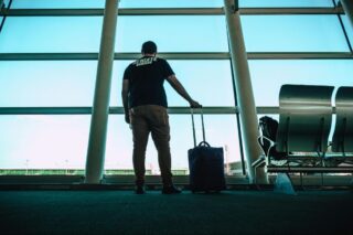 Man Standing at Airport Windows