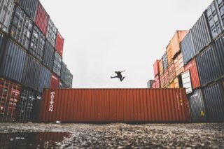 Person Jumping Over Shipping Container