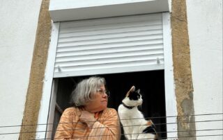 Woman Looking Out of Window with a Cat